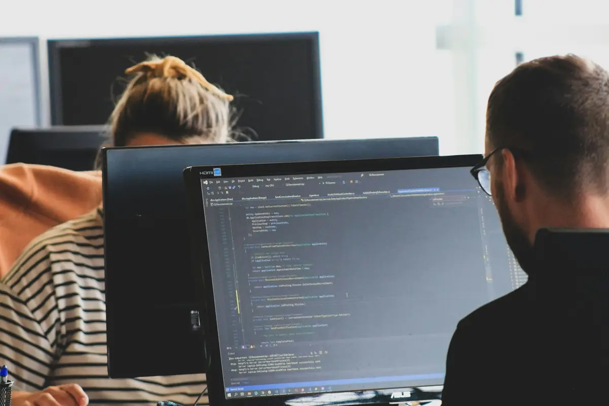 Two developers working side by side at their screens